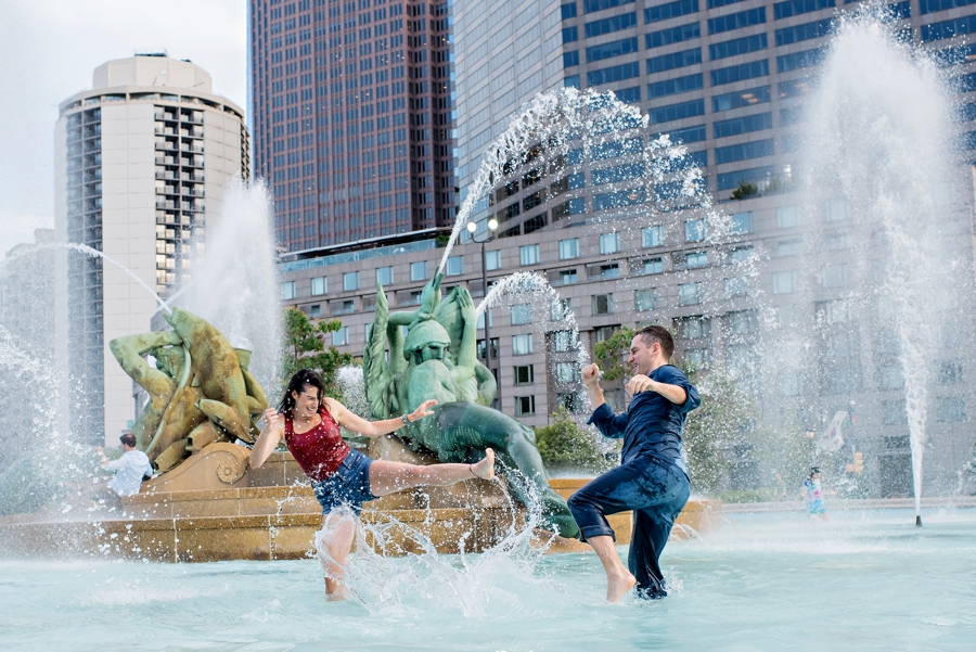 A newly engaged couple have a water fight in Swann Memorial Fountain in Philly.